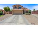 Charming home features a tile roof, two-car garage, and mature trees for a welcoming curb appeal at 12745 W Monte Vista Rd, Avondale, AZ 85392