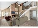 Inviting living room boasts a brick fireplace, beamed ceilings, and an open staircase at 20818 N 21St Dr, Phoenix, AZ 85027