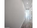 Long hallway with grey wood-look tile, leading to multiple rooms and offering a clean aesthetic at 2557 E Music Mountain Ave, Apache Junction, AZ 85119