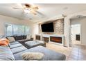 Inviting living room features a stone accent wall with fireplace, ceiling fan, and tile flooring at 11259 W Locust Ln, Avondale, AZ 85323