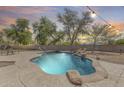 Beautifully landscaped pool area with a rock waterfall feature, creating a serene and inviting outdoor oasis at 11259 W Locust Ln, Avondale, AZ 85323