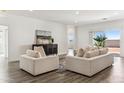 Spacious living room featuring contemporary sofas, stylish cabinet, and natural light, with views into adjacent rooms at 12246 E Agave Ln, Florence, AZ 85132