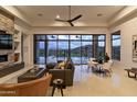 Stylish living room with desert views, a modern fan, and a stone fireplace at 15332 E Hidden Springs Trl, Fountain Hills, AZ 85268