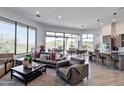 Bright, open-concept living room features large windows and access to an outdoor patio with dining and lounge furniture at 15332 E Hidden Springs Trl, Fountain Hills, AZ 85268