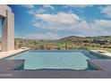 Inviting infinity pool with stunning panoramic views of a golf course and desert landscape at 15332 E Hidden Springs Trl, Fountain Hills, AZ 85268