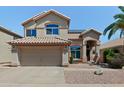Two-story home with a two-car garage, desert landscaping, and solar panels on the roof at 162 W El Freda Rd, Tempe, AZ 85284