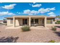 A covered backyard patio with a table and chairs overlooking the low maintenance landscaped yard at 19005 N Diamante Dr, Surprise, AZ 85387
