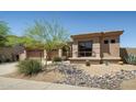 Charming home exterior with desert landscaping and a decorative rock stream feature at 23014 N 52Nd St, Phoenix, AZ 85054