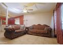 Open-concept living room featuring tile flooring, neutral paint, and classic couches that offer a cozy space at 2305 E Southern Ave, Phoenix, AZ 85040