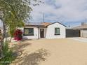 Well-kept single-story house with modern dark trim, desert landscaping, solar panels and privacy gate at 2628 W Marshall Ave, Phoenix, AZ 85017