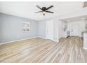 Bright living room featuring new flooring, fresh paint, modern ceiling fan, and a view into the kitchen at 2628 W Marshall Ave, Phoenix, AZ 85017