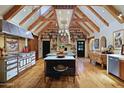 Spacious kitchen with wooden beams, a large central island and restaurant grade stove, oven and hood combination at 27050 N 103Rd St, Scottsdale, AZ 85262