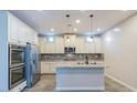 Modern kitchen boasts white cabinets, stainless steel appliances, and a center island at 3386 E Strawberry Dr, Gilbert, AZ 85298