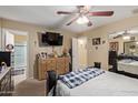 Bedroom showcasing a ceiling fan, dresser with decor, and ensuite bathroom access at 3411 W Redfield Rd, Phoenix, AZ 85053