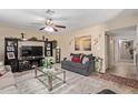 Comfortable living room featuring a ceiling fan, entertainment center, and neutral color scheme at 3411 W Redfield Rd, Phoenix, AZ 85053