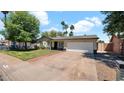 Inviting single-story home with a spacious driveway leading to an attached two-car garage at 4034 E Aster Dr, Phoenix, AZ 85032