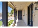 Inviting covered front porch of a home with a dark gray front door and matching painted pillars at 5452 E University Dr, Mesa, AZ 85205