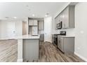 Charming kitchen with gray cabinets, stainless appliances, and island at 5828 E Covey Ln, Phoenix, AZ 85054