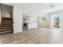 Bright open-concept living space with wood-look tile flooring and a view of the kitchen at 5828 E Covey Ln, Phoenix, AZ 85054