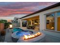 Outdoor living area with pool, spa, fire features, and covered patio, perfect for entertaining at twilight at 644 E Las Puertas Ln, Queen Creek, AZ 85140
