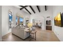 Bright living room features a beamed ceiling, large windows with outdoor views, and stylish furniture at 10025 E Larkspur Dr, Scottsdale, AZ 85260