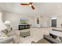 Spacious living room featuring a ceiling fan, comfortable seating, and entertainment center at 15766 W Grand Point Ln, Surprise, AZ 85374
