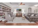 Cozy living room featuring built-in bookshelves, stylish seating, and a decorative ceiling fan at 16603 N 168Th Dr, Surprise, AZ 85388