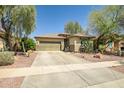 Charming single-story home featuring a well-manicured lawn, desert landscaping, and a spacious two-car garage at 16924 W Stevenage St, Surprise, AZ 85374