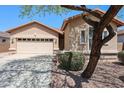 Inviting front exterior showcasing a two-car garage and desert landscaping features at 17050 W Manchester Dr, Surprise, AZ 85374