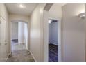 Hallway featuring arched doorways, tile flooring and neutral paint at 17050 W Manchester Dr, Surprise, AZ 85374