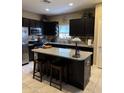 Eat-in kitchen featuring granite countertops, an island with seating, and stainless-steel appliances at 20230 N Jill Ave, Maricopa, AZ 85138