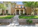 Charming two-story townhome featuring lush greenery, stone accents, and a welcoming front porch at 21109 W Sunrise Ln, Buckeye, AZ 85396