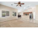 Open-concept living room featuring a ceiling fan, view of the kitchen bar and dining area at 2329 E Ebony Dr, Chandler, AZ 85286