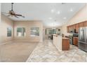 Open-concept living space featuring a ceiling fan, neutral paint, and views of the kitchen and dining area at 2329 E Ebony Dr, Chandler, AZ 85286