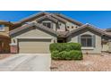 Charming home with a two-car garage, well-maintained landscaping, and desert-style rock ground cover at 23848 W Grove St, Buckeye, AZ 85326