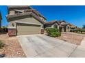 A charming house features desert-style landscaping, an attached garage and a concrete driveway at 23848 W Grove St, Buckeye, AZ 85326