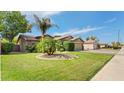 Beautiful home with a well-manicured lawn, mature trees, and a two-car garage at 2585 E Morgan Dr, Gilbert, AZ 85295