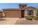 Charming single-story home featuring a stone facade, two-car garage, and desert landscaping for low maintenance at 296 N Jesse St, Chandler, AZ 85225