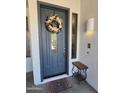 Stylish blue front door with decorative wreath and side window at 2977 E County Down Dr, Chandler, AZ 85249