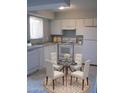 Bright kitchen with all-white appliances and cabinetry, paired with a cozy dining area at 3605 W Bethany Home Rd # 7, Phoenix, AZ 85019