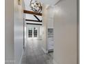 Hallway with tiled floor leading to a sunroom with french doors and decorative ceiling light at 4165 E Huntington Dr, Phoenix, AZ 85040