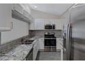 Well-equipped kitchen featuring stainless steel appliances, granite countertops, and white cabinets at 4165 E Huntington Dr, Phoenix, AZ 85040