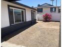 Backyard with white walls, gravel and a bright pink flowering bush at 4210 W Solano Dr, Phoenix, AZ 85019