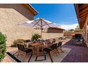 A backyard patio offers outdoor dining with the umbrella-covered table, grill, and desert landscaping at 5221 E Tunder Cir, Phoenix, AZ 85044