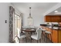 This dining room has an eat-in kitchen, a wood table and a sliding door leading to the back yard at 5221 E Tunder Cir, Phoenix, AZ 85044