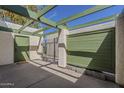 Private patio with a green-covered pergola, a convenient entry door, and a secure metal gate, offering a serene outdoor space at 536 S Evergreen Rd, Tempe, AZ 85288