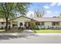 Charming single-story home with a stone facade, manicured lawn, and mature shade trees, boosting curb appeal at 613 E Vista Ave, Phoenix, AZ 85020