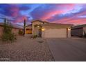 Charming single-story home with a two-car garage, low maintenance desert landscaping, and a stunning sunset at 6853 S Russet Sky Way, Gold Canyon, AZ 85118