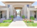Community pool entrance with stone pillars, desert landscaping, and decorative flowers at 7009 E Acoma Dr # 1160, Scottsdale, AZ 85254