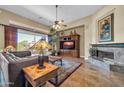 Cozy living room with fireplace, media center and lots of light from a big window at 7500 E Pontebella Dr, Scottsdale, AZ 85266